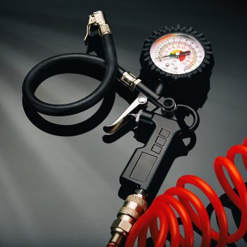 the pressure gauge of the compressor to control the pressure in the tires on a dark background closeup